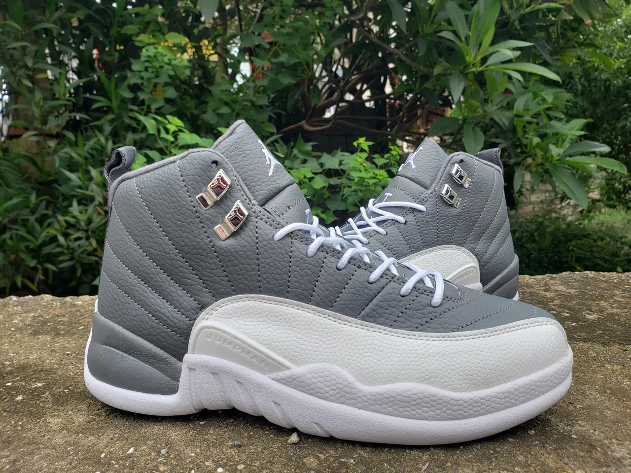 Chaussures de basketball Air Jordan 12 gris et blanc avec tige en cuir matelassé et verrous de lacets métalliques 4