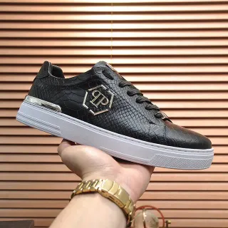 Tênis de couro preto com logo hexagonal de ouro e embossagem de serpente