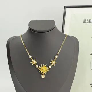 Collier de perles avec motif soleil et étoile en ton doré