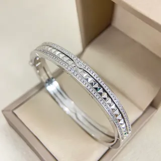 Brazalete con bisagra de tono plateado con cristales pavé y studs de pirámide