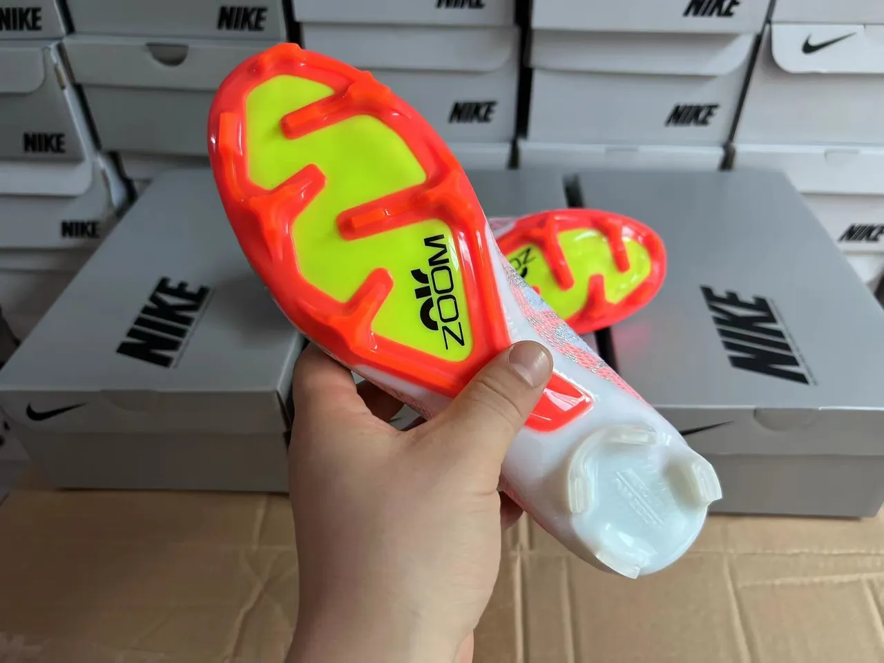 Nike chaussures de football blanches et oranges avec upper Flyknit, coupe basse, col de chaussette, terrain ferme 3