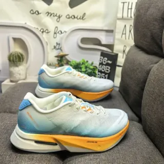 Tênis de corrida com upper de malha gradiente azul laranja, acento na midsole