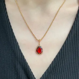 Colar com pingante de gota dourado com pedra vermelha com bordas de contas