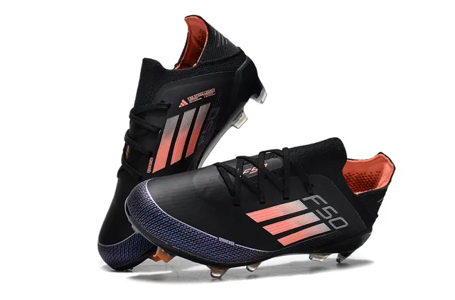 Adidas Zapatos de fútbol de corte bajo con upper sintético negro y naranja con detalles de franjas en gradiente para terreno firme 3