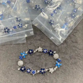 Bracelete de pedra com motivos florais e de estrela em azul e transparente