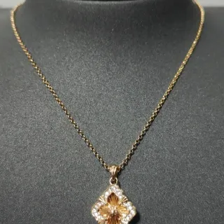 Colar com pingente floral de quatro folhas em tom dourado com pave