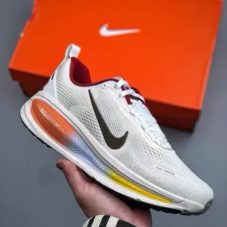 Nike Zapatos de correr blancos y naranjas con parte superior de malla ingenieril visible con amortiguación Zoom X