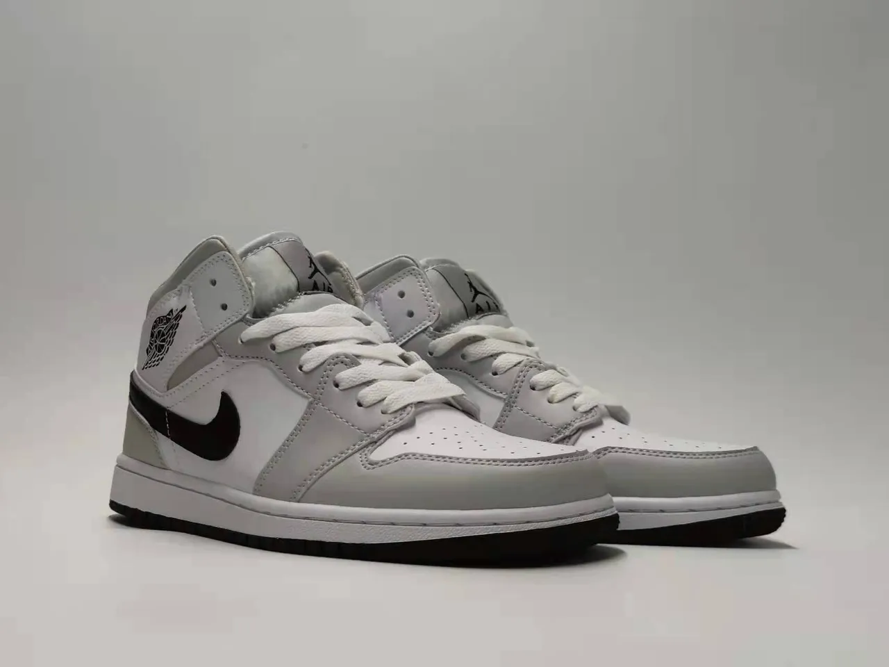 Chaussures de basketball Air Jordan 1 Mid silhouette gris et noir avec empiècements en cuir et matière synthétique 4