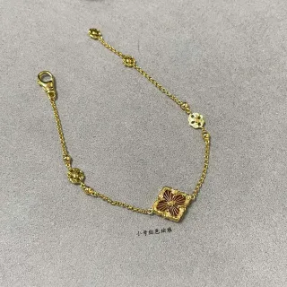 Pulsera con motivo floral de tono dorado y esmalte rojo