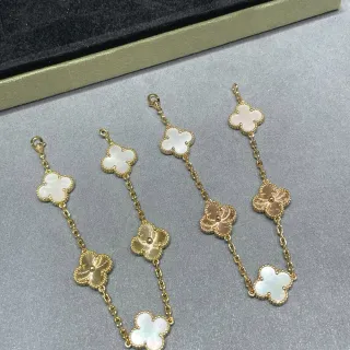 Pulseira de corrente dourada e branca com pingentes em forma de trevo