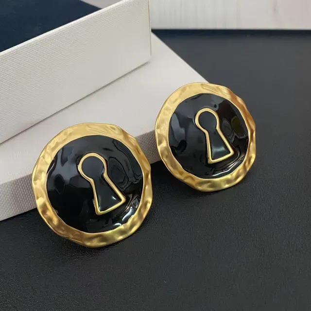 Broches de esmalte preto com motivo de chave em tom dourado martelado 5