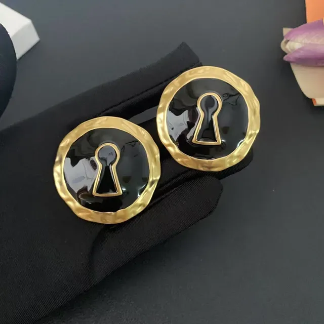 Broches de esmalte preto com motivo de chave em tom dourado martelado 6