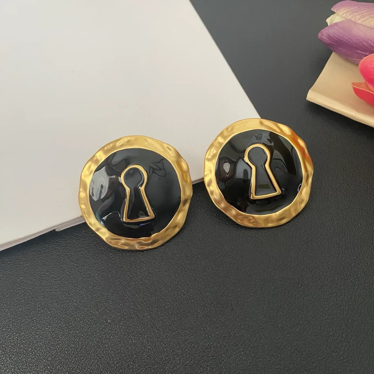 Broches de esmalte preto com motivo de chave em tom dourado martelado 9