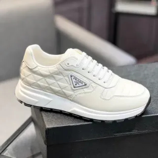 Prada Cloudbust بيج أسود جلد مبطن بخياط الماس لوحة الشعار المثلثة المعدنية حذاء رياضي أسلوب الحياة