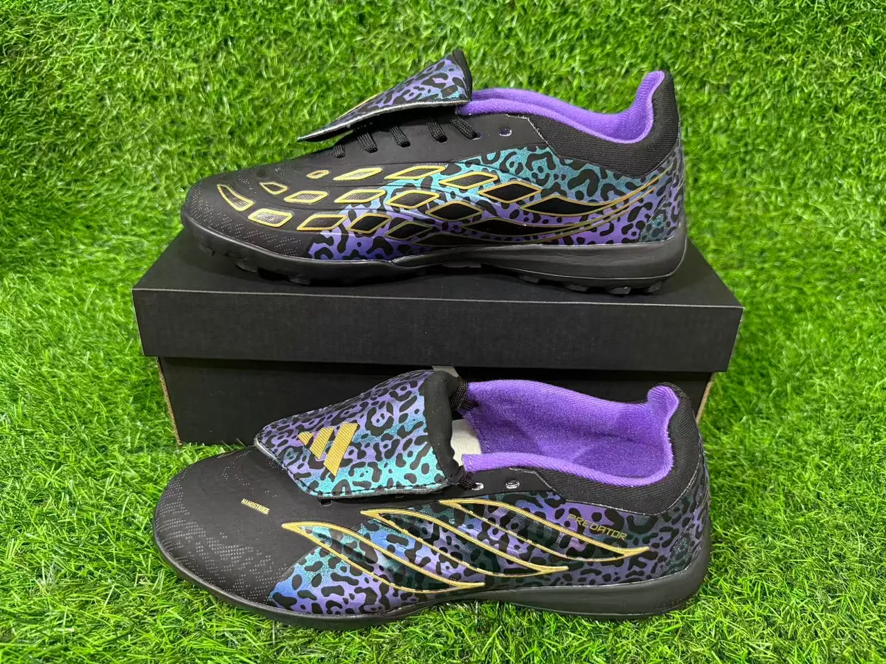 Adidas Chaussures de football noires multicolores à motif léopard iridescent sur le dessus avec bande dorée overlay de cage d'herbe artificielle 7