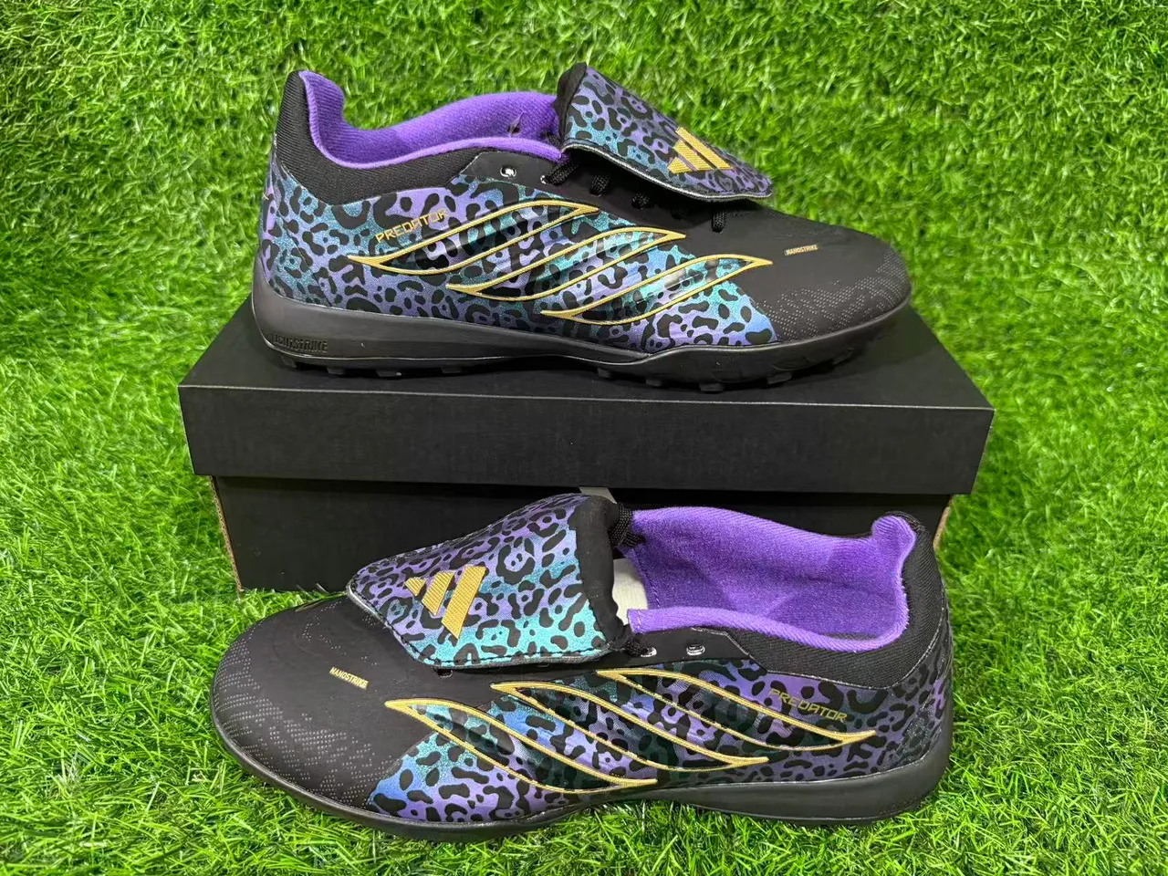 Adidas Chaussures de football noires multicolores à motif léopard iridescent sur le dessus avec bande dorée overlay de cage d'herbe artificielle 9