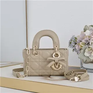 Bolsa Boston beige acolchada con asa superior, correa de cadena y acento de lazo