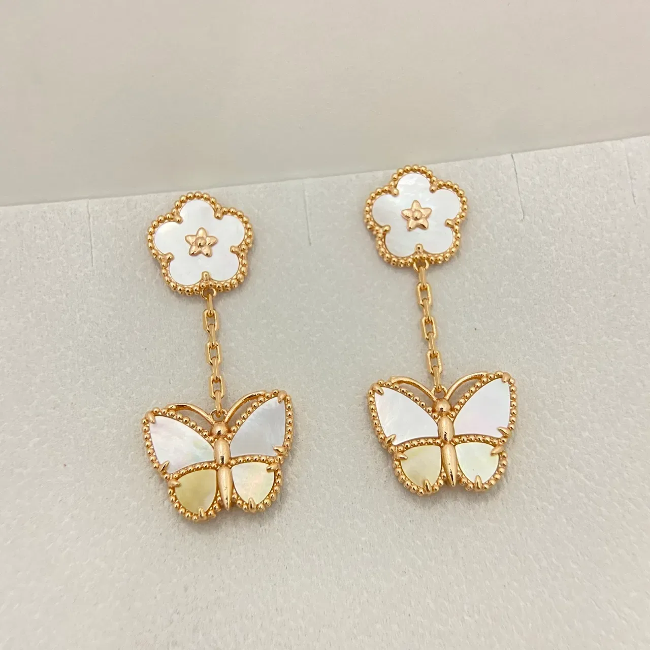 Boucles d'oreilles pendantes en ton doré avec motif floral à papillon en nacre 3