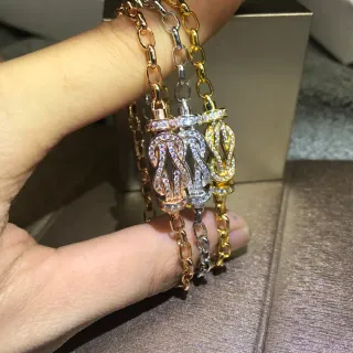 Pulseras de eslabones con charm de nudo pavé en tres tonos