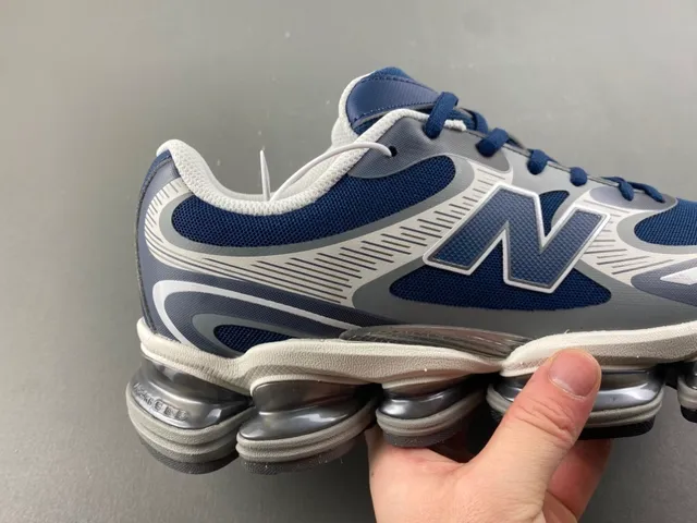 New Balance Chaussures chunky sneakers Navy Gray, cushioning d'air segmenté visible, upper en mesh et synthétique en couches 3